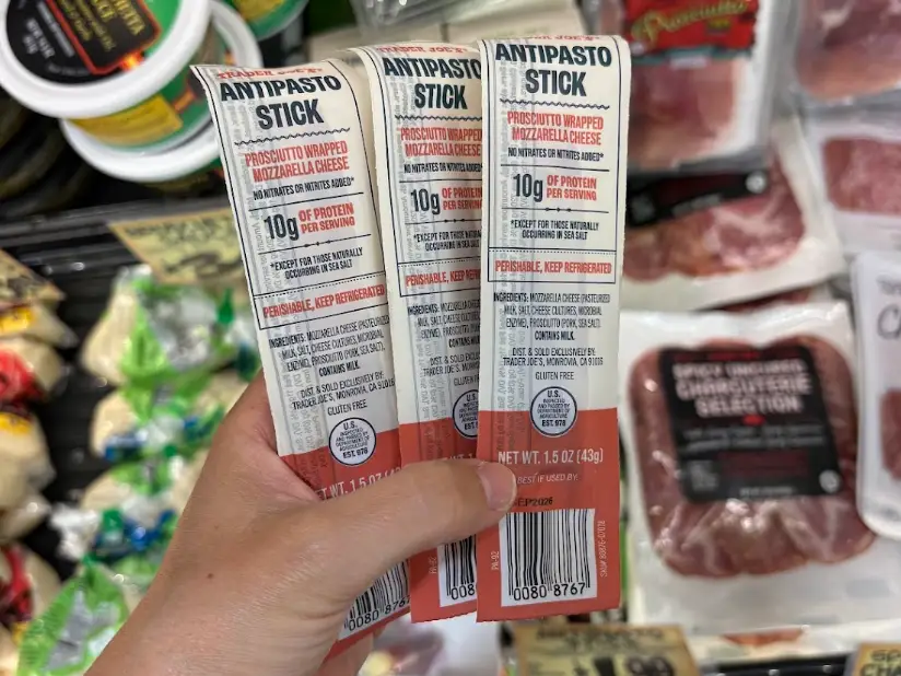 The writer holding antipasto sticks at Trader Joe's.